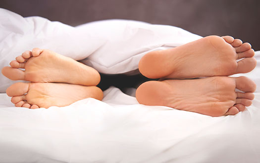 Couple's feet in bed